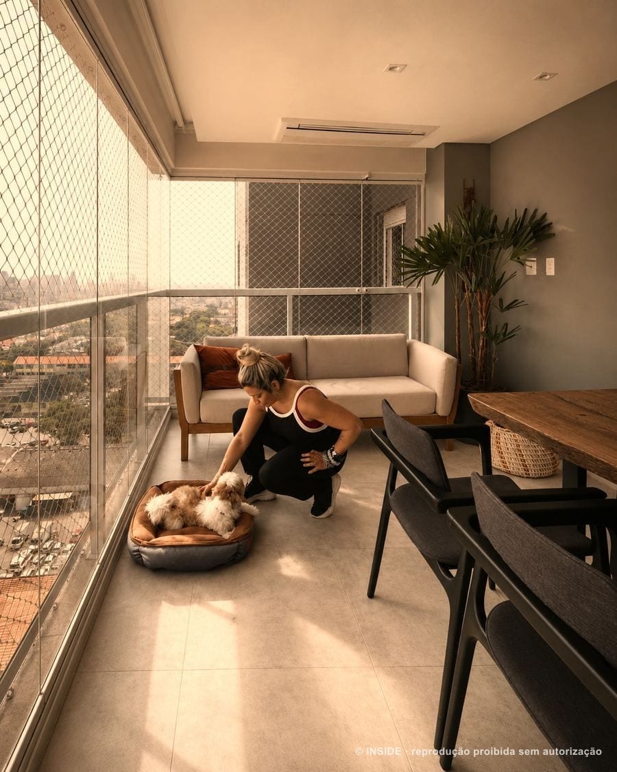 Sara Rollemberg com o cachorro de um cliente durante visita de projeto, bastidores INSIDE, 2026, acervo INSIDE