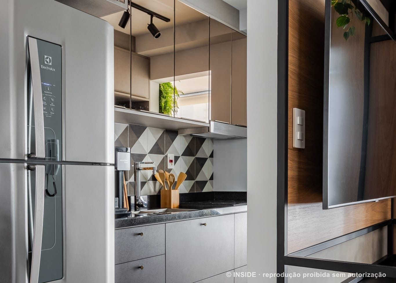 Vila Mariana: a cozinha integrada com backsplash geometrico e marcenaria amadeirada, foto Alberto Ricci