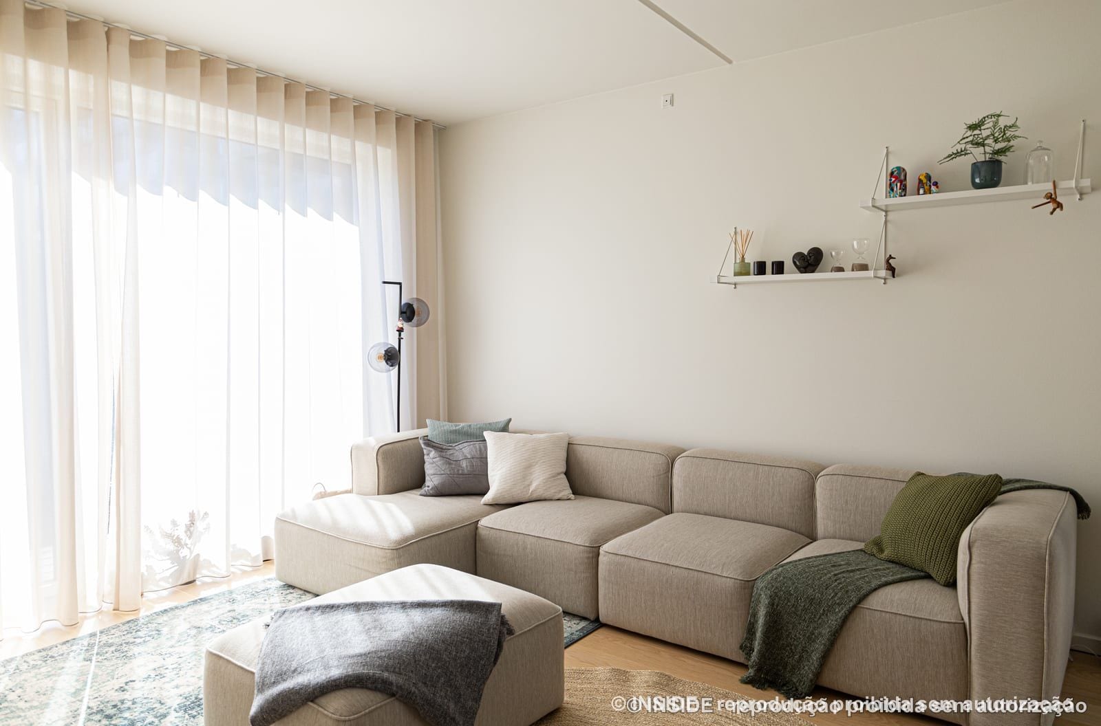 O sofá modular claro sob a prateleira suspensa de metal branco, projeto INSIDE em Copenhague, 2022