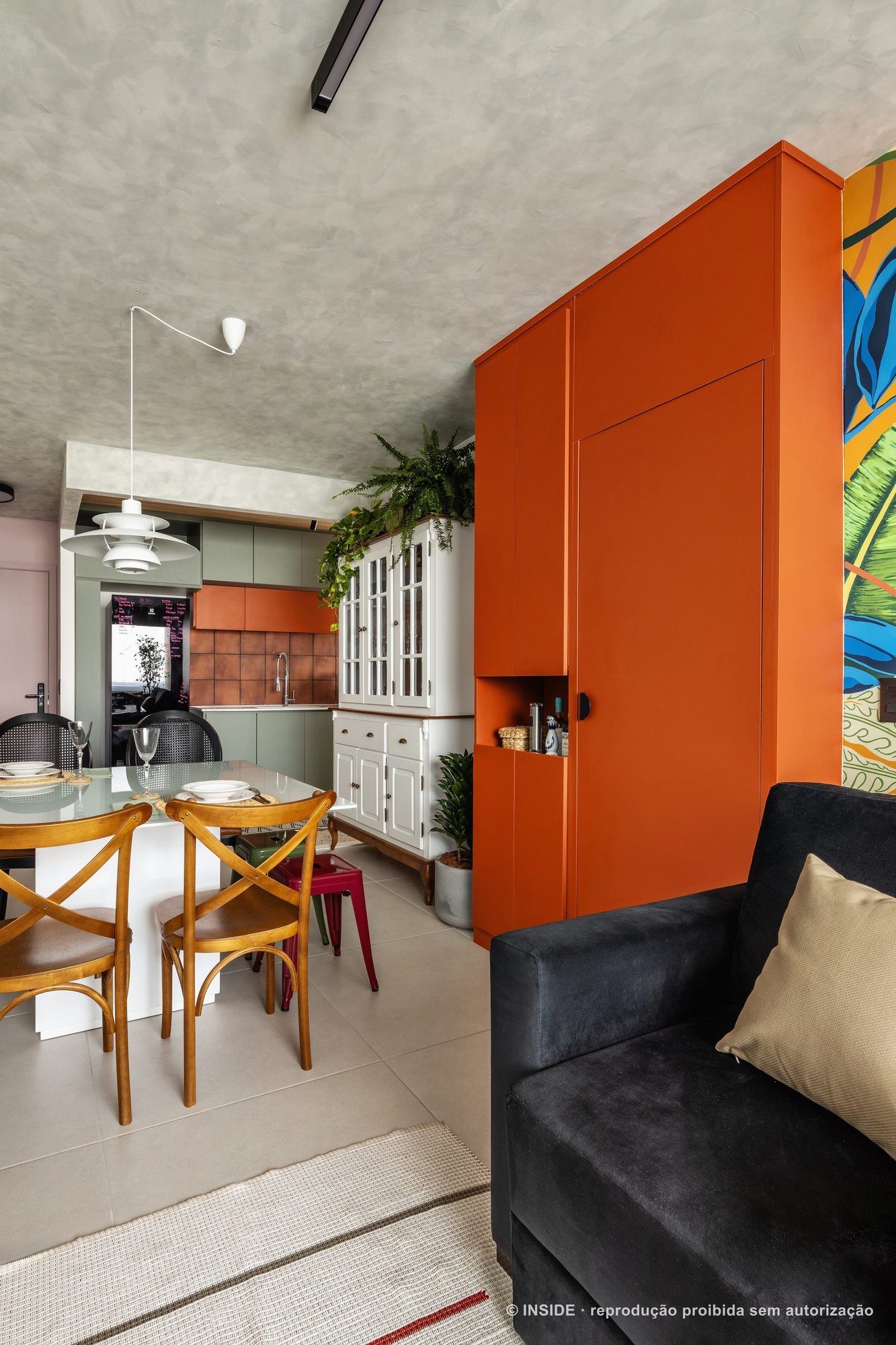 Cozinha e sala integradas com marcenaria laranja, mural tropical de folhagens, cozinha verde e teto de concreto, projeto INSIDE