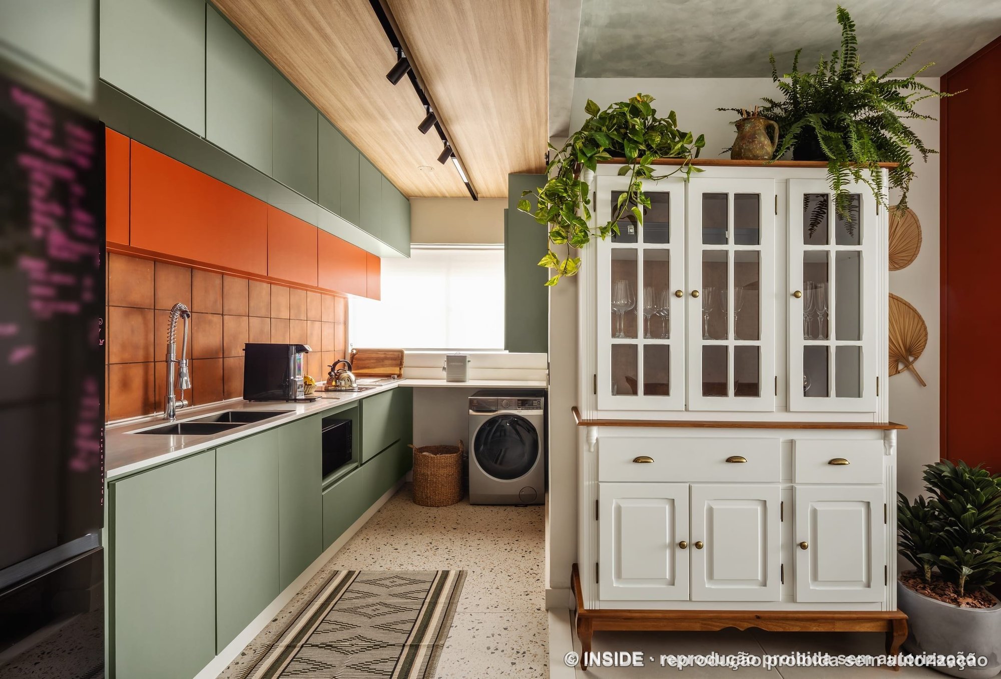 Cozinha com marcenaria verde, armários laranja, revestimento acobreado e cristaleira branca, projeto INSIDE